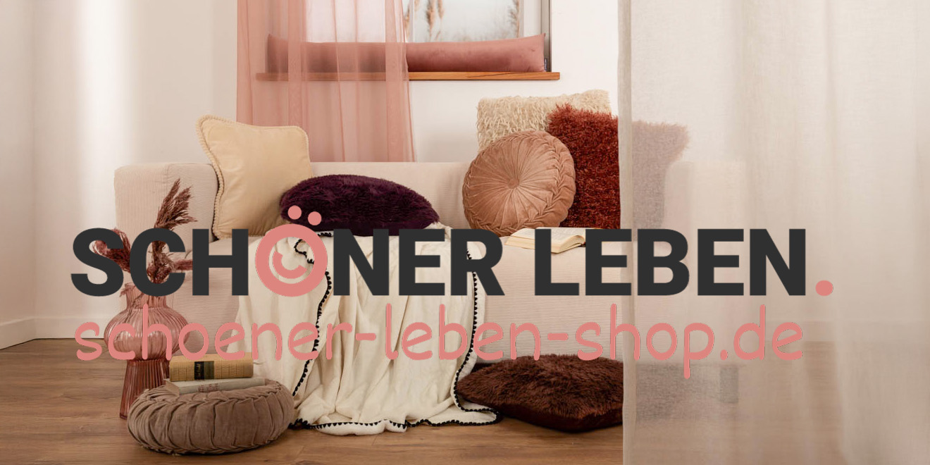 „Wohnzimmer mit beigefarbener Couch, dekoriert mit Kissen in warmen Tönen wie Beige, Rostrot und Dunkellila, einer hellen Decke und rosafarbenem Vorhang. Im Vordergrund steht eine rosa Vase mit Trockenblumen und ein runder Sitzpouf. Textüberlagerung: ‚Schöner Leben – schoener-leben-shop.de‘