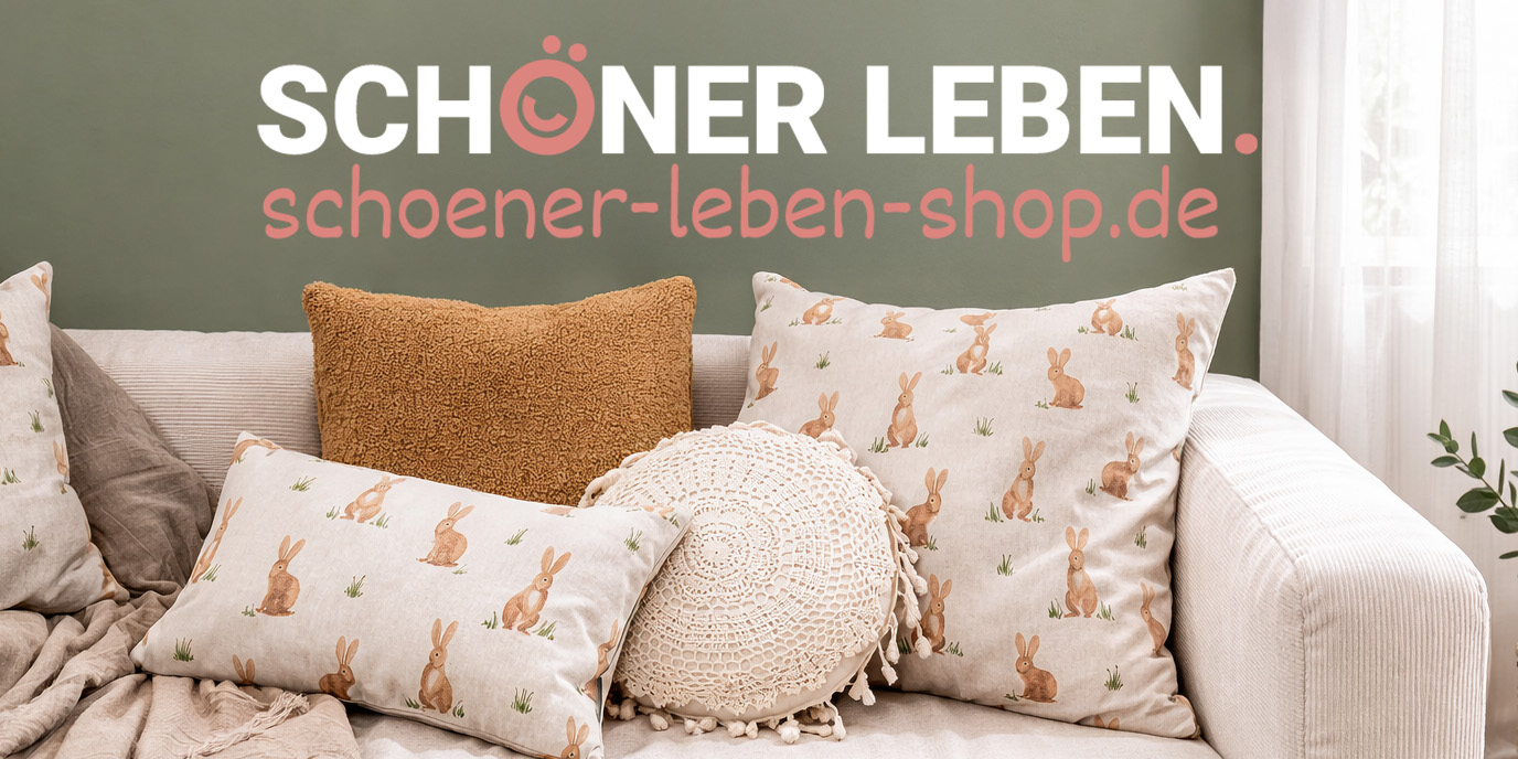Sofa mit dekorativen Kissen in Natur- und Grüntönen, darunter Kissen mit Hasenmotiv; darüber der Schriftzug ‚Schöner Leben – schoener-leben-shop.de‘.